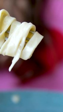Piatto di deliziosi spagetti alla carbonara, una tipica ricetta di pasta condita con una salsa a base di uova, pecorino e guanciale, cibo italiano. Beceriksiz kız bir çatala spagetti sarar.
