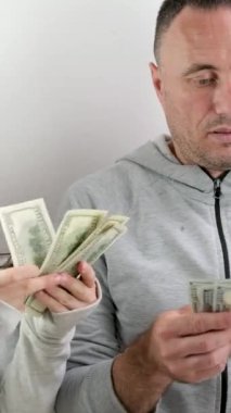 Babası kızına eski 100 dolarlık banknotları saymayı öğretiyor ve yeni banknotlar duvarın yanında duran aile tabloları konuşmayı düşünüyor. iletişim