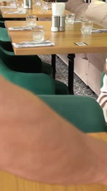 Lokantada portakal suyu krepleri, meyveler, ekşi krema, hindistancevizi taneleri ve kızarmış karidesli öğle yemeği yumurtası ve çizgili kazaklı avokado kız ahşap masada oturuyor.