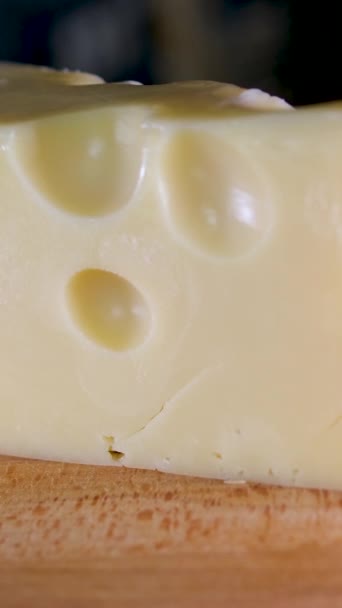 女性的手在木制切菜板上用刀切奶酪 优质4K影片垂直录影 — 图库视频影像