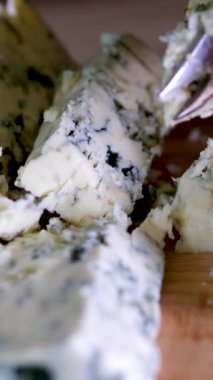 Siyah tabakta rotasyon peyniri. Arka plandaki kesme tahtasındaki Dorblu peyniri. Yüksek kalite 4k görüntü dikey video