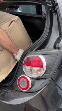 Yeni posta bagaj bölmesi büyük paket kutuları araba sorunlu bagaj taşıyıcısına yüklendi kırmızı tişörtlü tramvay teslimatı Ukrayna Vinnitsa 09.09.2023