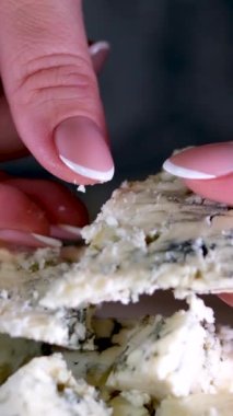 Siyah tabakta rotasyon peyniri. Arka plandaki kesme tahtasındaki Dorblu peyniri. Yüksek kalite 4k görüntü dikey video