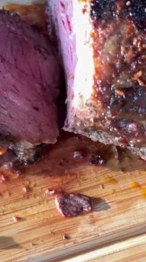 Chef cuts the roast beef into thin pieces and puts them in a pile on a cutting board. High quality 4k footage