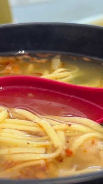 Sup Oriental Dalam Piring Hitam Dengan Sendok Sendok Merah Asia — Stok Video