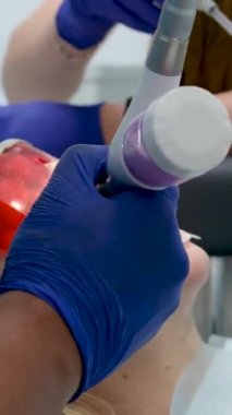 Bir diş kliniğinde diş temizliği, taş ve plaket çıkarmak, bir kadınla çalışan genç uzmanlar, salya püskürtücüsünü temizlemek, tükürük emmek, dişlere boya sürmek,