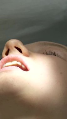 Diş hekimliği ergenliği, sarı eldivenli bir doktor dişçide dişçiye yakın çekim videosu için genç bir kızın dişini doldurur ve dişini yeni teknolojilerle kurutur. modern klinik