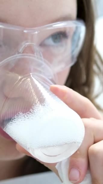 プラスチック製のガラスが付いている若い美しい十代の少女は透明なガラスで泡が付いている歯科飲料水で歯を得ます 口腔衛生の遅い動きのビデオ 顔を閉じる — ストック動画