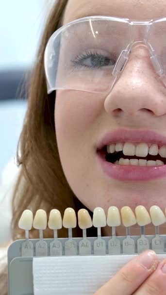 歯を白くする 完全な白い王冠の歯は日陰ガイドの漂白色 女性のベニヤの笑顔 歯科ケアおよび茎学 コピースペースと近づきます — ストック動画