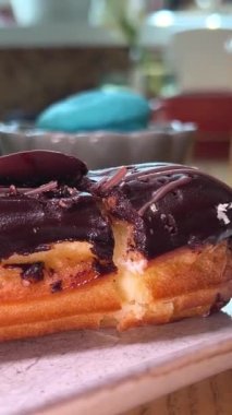 Kremalı pasta, arka planda deniz dikenli çikolatalı çay ve portakallı beyaz tabakta servis edilen ahşap bir masada lezzetli bir tatlı dükkanında servis edilen bir restoranda servis edilir. tereyağı kreması