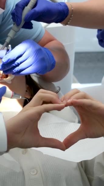 Junges Mädchen Zeigt Herz Mit Händen Sitzen Zahnarztpraxis Zähneputzen Zahnaufhellung — Stockvideo
