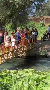 UNESCO 'nun ünlü turistleri Mavi Göz' ü listeye aldılar, insanlar nehir üzerindeki köprü boyunca yürüyorlar. Arnavutluk 09.09.2023