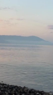 Makedonya ve Arnavutluk sınırında Torino Gölü berrak su gün doğumu veya gün batımı mavi gökyüzü