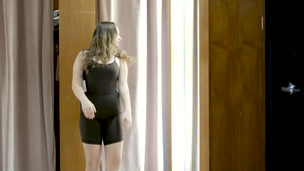 フィッティングルームの女の子は タグロッカールームのフィッティングルームボディスーツで新しいスポーツタイトなスーツ服を着ています 美しい図の贅沢なカナダバンクーバー 服のジムの選択のための高価な生命 — ストック動画