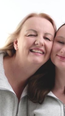 Güzel, gülümseyen bir kız çocuğu anne kameraya bakar. Mutlu güzel bir aile genç bekar bir anne koruyucu anne ve tatlı bir kız kucaklaşması tatlı aşk konseptinin tadını çıkar..