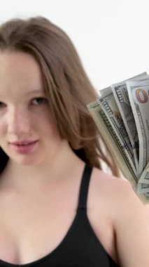 Beyaz bir arka planda rüzgarda gelişmekte olan bir kadının 100 dolarlık banknotları. Güzellik salonlarına harcanan paranın çoğu rüzgâr gülüşünde pahalı paralar. Kendine güven