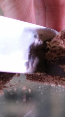 Kadın eli ve cam masaya yakın duran bir bıçak Fransız tatlısını bir sürü gözenekli fırın yapısı ile kesiyor. Badem hamurunun yapısını kontrol eden lezzetli taze badem kurabiyeleri.