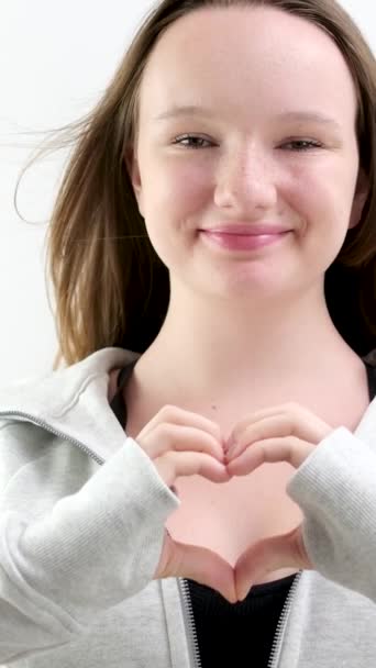 笑顔の若い女性ボランティアは カメラを見ている手のサインハートの形を示しています 健康な心臓の健康寿命保険 愛と慈善団体 ボランティア社会 臓器提供コンセプト 肖像画を閉じる — ストック動画