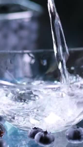 Blaubeeren Auf Dem Tisch Verteilt Gießen Sie Wasser Eine Glasschale — Stockvideo