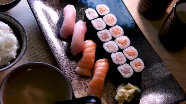 Složení Různých Druhů Sushi Rolí Umístěných Černé Kamenné Desce Hůlky — Stock video