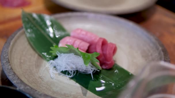 金枪鱼鱼肉配米粉 铺上酱汁 上面撒满了黄金装饰 可食用的莴苣叶 用一只戴着手套的雄性手在餐馆里烹调 很好吃 Sushiya — 图库视频影像