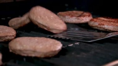Açık ateşte pişmiş bir hamburger için barbekü ve kızarmış kıymalı kıymalı köfteler ve ateşte pişirilmiş bir spatulayla çok lezzetli bir dönüş. Ateş yanıyor ve çok lezzetli..
