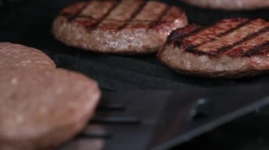 Açık ateşte pişmiş bir hamburger için barbekü ve kızarmış kıymalı kıymalı köfteler ve ateşte pişirilmiş bir spatulayla çok lezzetli bir dönüş. Ateş yanıyor ve çok lezzetli..