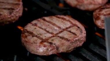 Açık ateşte pişmiş bir hamburger için barbekü ve kızarmış kıymalı kıymalı köfteler ve ateşte pişirilmiş bir spatulayla çok lezzetli bir dönüş. Ateş yanıyor ve çok lezzetli..