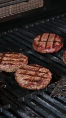 Hamburgerler alevli ızgarada soğuyor, ağır çekimde. Phantom Flex 4K kamerayla çekilmiş. Yüksek kalite 4k görüntü