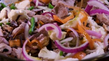 Kızartma tavasında sığır eti pişirmek için doğranmış sarımsak ve zencefil ekleyin. Zeytinyağında pişmiş çiğ et yakın plan Oriental gıda vermicelli Wok sıcak yağ sıçramalarını pişirmeye başlar. Pişerken çiğ et