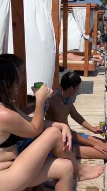 Gençler İyon Denizi 'nde tatil yapıyor. Arnavutluk gençlik arkadaşları nehir kıyısında bir hamakta yatıyor. Bir kız ve dört erkek Arnavutluk' ta Ksamil 09.09.2023