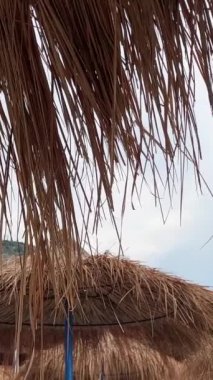 Güzel bir yaz günü, sabahın erken saatlerinde Arnavutluk Riviera 'sı boyunca resim gibi yazlık kulübeler. Arnavutluk 'un Borsh köyündeki sahil. Açık gökyüzü tatilcileri. İnsanlar güzel deniz İyon denizi.