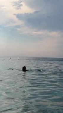 Güzel bir yaz günü, sabahın erken saatlerinde Arnavutluk Riviera 'sı boyunca resim gibi yazlık kulübeler. Arnavutluk 'un Borsh köyündeki sahil. Açık gökyüzü tatilcileri. İnsanlar güzel deniz İyon denizi.