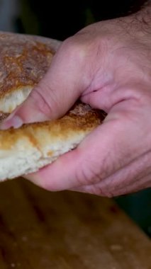 Kafkasyalı fırıncı ekmeği iki parçaya ayırır. Beyaz ekmeği kırmaya yakın çekim. Yüksek kalite 4k görüntü