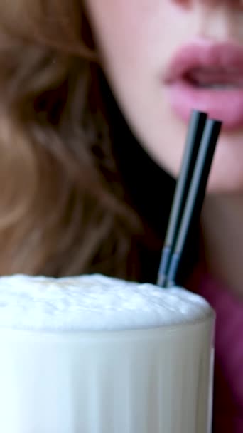 アウトドアカフェでメタルストローでアイスラテを飲む陽気な女性 高品質の4K映像 — ストック動画