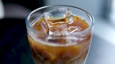 Sütsüz süt yulaflı buzlu latte ya da lezzetli bir tatlı içeceğin içinde muz bademli hindistan cevizi sütü yakın plan makro fotoğrafçılığa buz ekle. çeşitli videolar