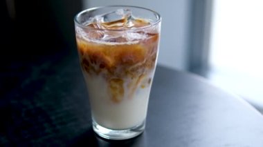 Sütsüz süt yulaflı buzlu latte ya da lezzetli bir tatlı içeceğin içinde muz bademli hindistan cevizi sütü yakın plan makro fotoğrafçılığa buz ekle. çeşitli videolar