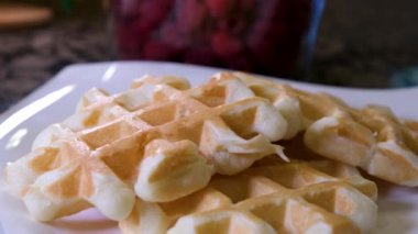 Elektrikli waffle demiriyle lezzetli waffle hazırlama süreci yumurtanın malzemelerini yeniliyor. Un, şekere yakın yemek tarifi ekliyor. Ahududulu kahvaltı bir dizi video dekore eder.