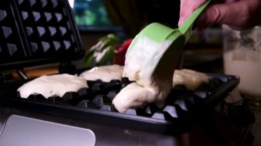 Elektrikli waffle demiriyle lezzetli waffle hazırlama süreci yumurtanın malzemelerini yeniliyor. Un, şekere yakın yemek tarifi ekliyor. Ahududulu kahvaltı bir dizi video dekore eder.