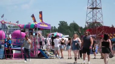 Vancouver 'da izinli insanlar içki alırlar salıncaklara binerler kovboy şapkaları giyerler parkta yürürler Surrey Kanada şehrinde gerçek insanlar 05.20.2023