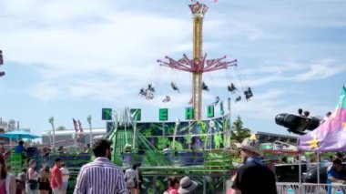 Vancouver 'da izinli insanlar içki alırlar salıncaklara binerler kovboy şapkaları giyerler parkta yürürler Surrey Kanada şehrinde gerçek insanlar 05.20.2023