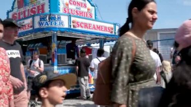 Vancouver 'da izinli insanlar içki alırlar salıncaklara binerler kovboy şapkaları giyerler parkta yürürler Surrey Kanada şehrinde gerçek insanlar 05.20.2023