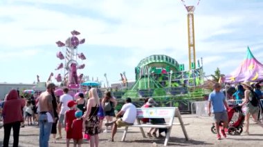 Vancouver 'da izinli insanlar içki alırlar salıncaklara binerler kovboy şapkaları giyerler parkta yürürler Surrey Kanada şehrinde gerçek insanlar 05.20.2023