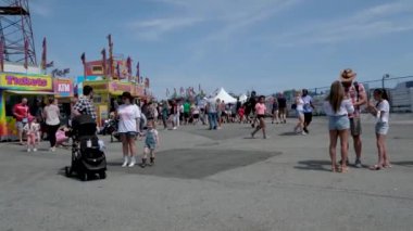 Vancouver 'da izinli insanlar içki alırlar salıncaklara binerler kovboy şapkaları giyerler parkta yürürler Surrey Kanada şehrinde gerçek insanlar 05.20.2023