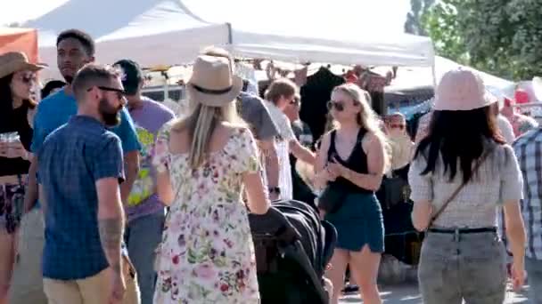 バンクーバーの人々は スイングライドに乗ってドリンクを購入し 公園でカウボーイハットロデオを着用し サリーカナダの街で実在の人々と散歩 — ストック動画