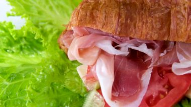 Jamonlu jambonlu kruvasan sandviçi ve domatesli marul sebzeler, Fransa 'da kahvaltıda sağlıklı, pahalı ve zengin peynirleri beyaz tabakta bırakır. pahalı restoran