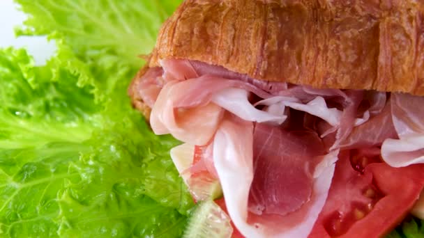 トマトレタスと肉ジャムソンプロシュットとクロワッサンサンドイッチは フランスの朝食で自然健康的な健康的な高価なチーズの豊富な部分を白いプレートに残します 高価なレストラン — ストック動画