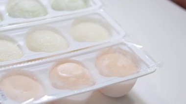 Asya tatlısının farklı tatları, bir el bezelye ve bir kutudan pirinç nişastası hamurundan yapılan tatlı dondurmayı alır. beyaz tabak