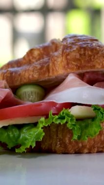 Jamonlu jambonlu kruvasan sandviçi ve domatesli marul sebzeler, Fransa 'da kahvaltıda sağlıklı, pahalı ve zengin peynirleri beyaz tabakta bırakır. pahalı restoran