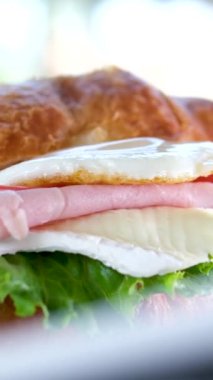 Yumurtalı, etli, domatesli ve Brie peynirli kruvasan Fransa 'da lüks bir otelde sunulan bir tabakta öğle yemeği. Bir gurme için yemeğin tadını çıkar. Portakal suyunun yanında.